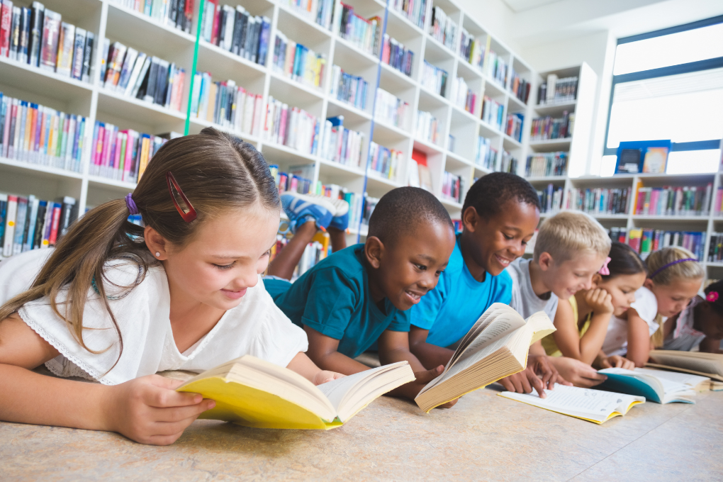 Group of diverse children reading together in a library — ideal for showcasing reading and phonics resources on grade.co.za that support early literacy and CAPS-aligned language development from Grade R to Grade 3.