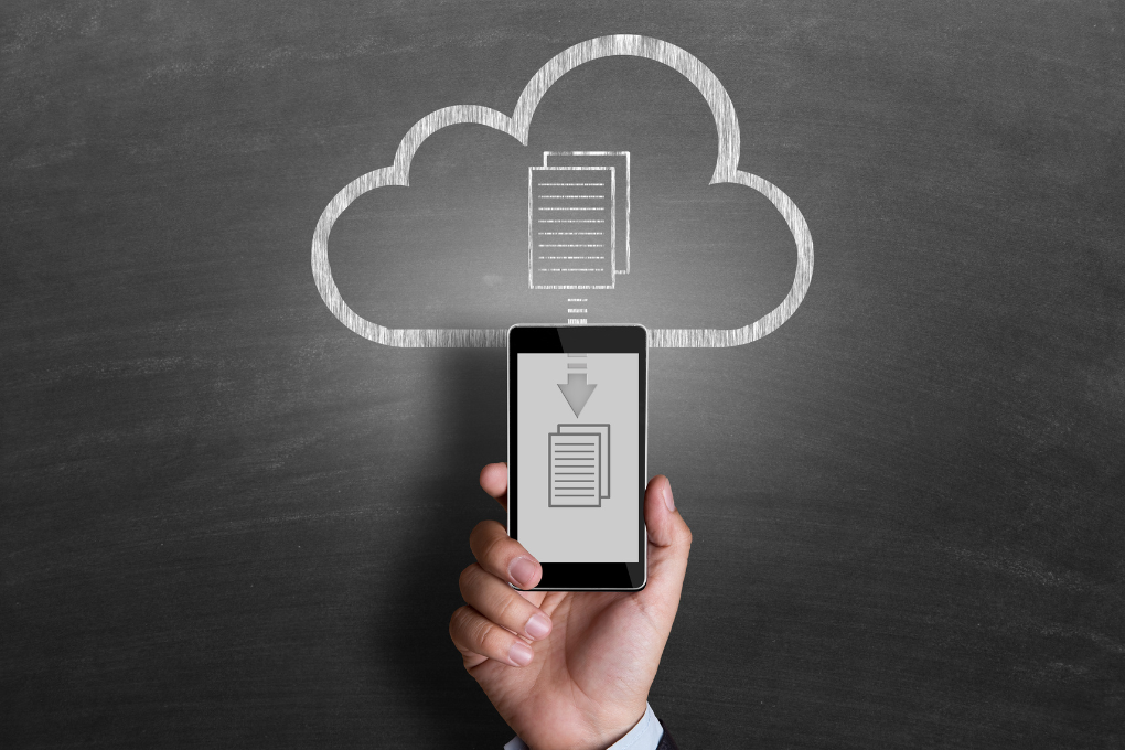 Smartphone displaying a download icon in front of a chalkboard with a cloud graphic