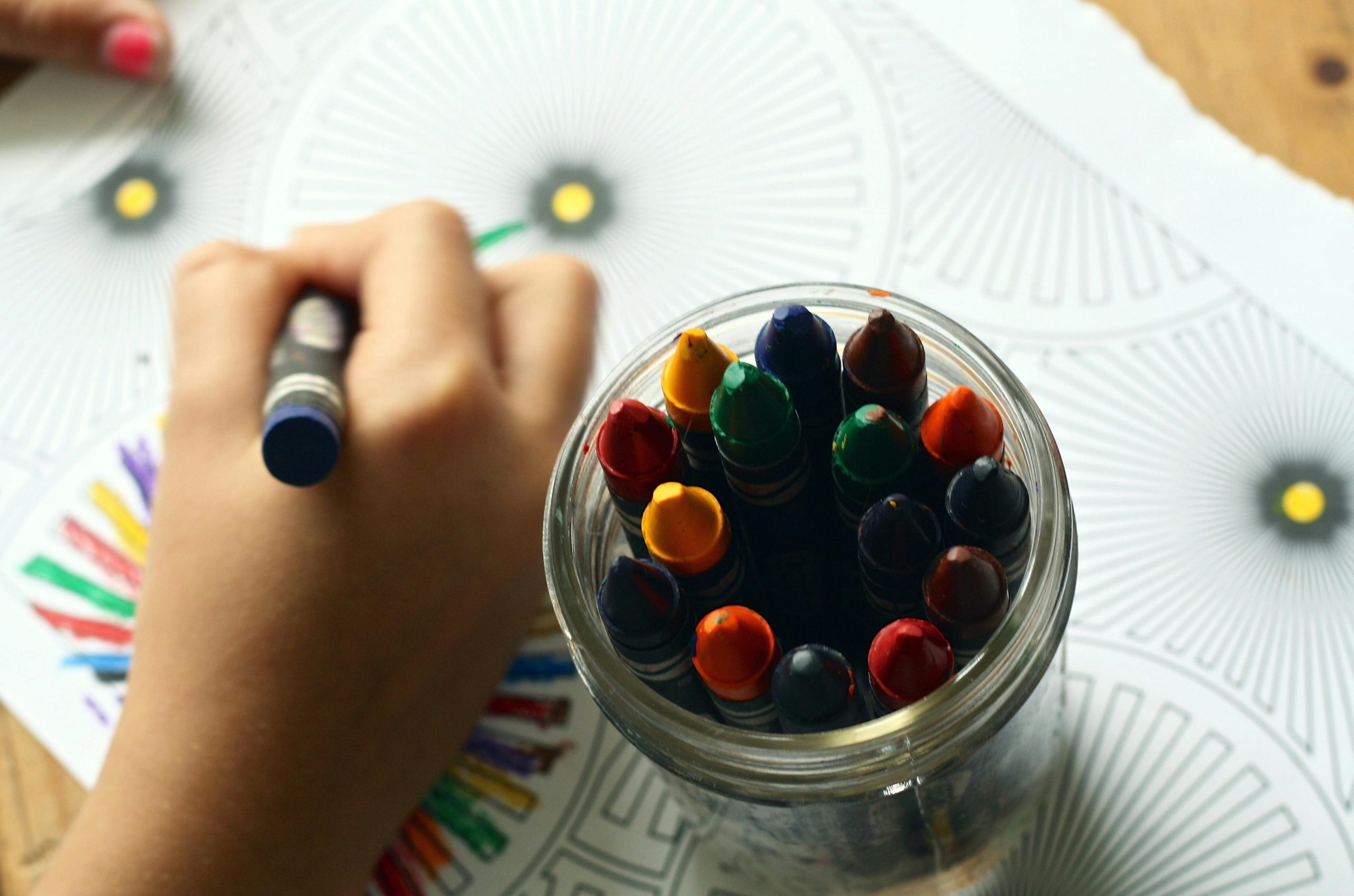 An older child or tween using detailed techniques to complete a complex coloring design