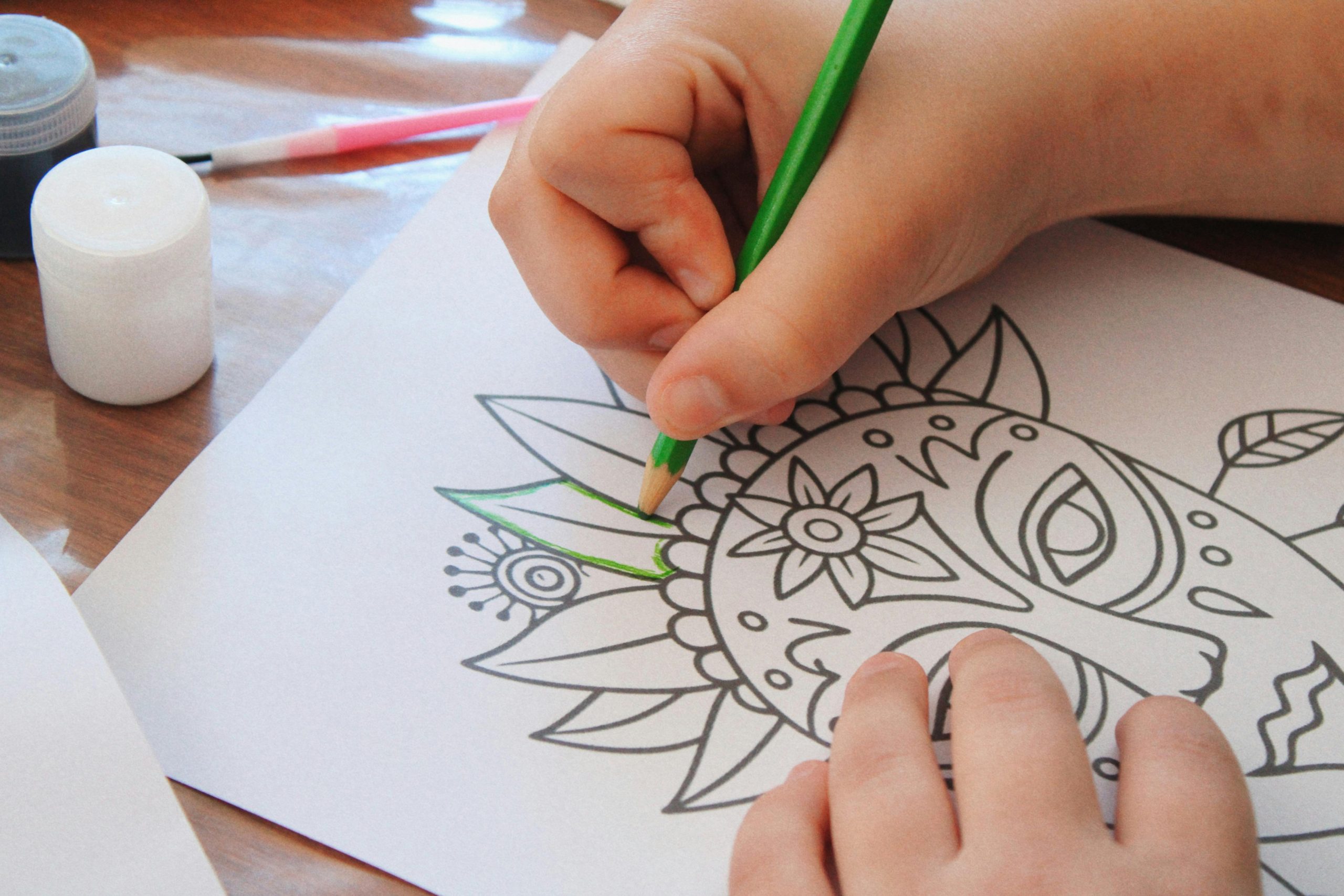 A child carefully coloring a more detailed scene with multiple elements.